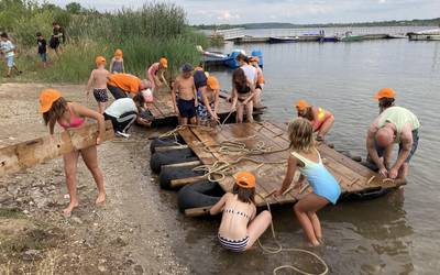 Am Ufer des Geiseltalsees bauen Kinder und Erwachsene aus Holzbrettern und Schläuchen ein Floß